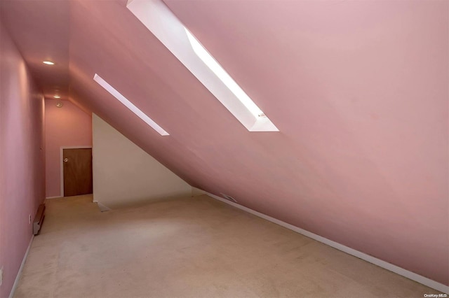 bonus room with vaulted ceiling with skylight and light colored carpet