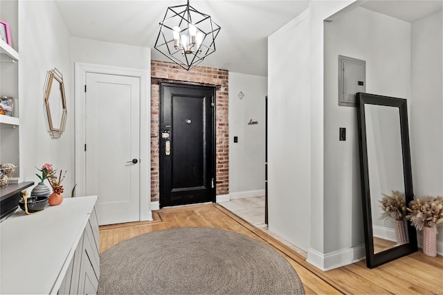 foyer entrance featuring a notable chandelier, electric panel, and light hardwood / wood-style flooring