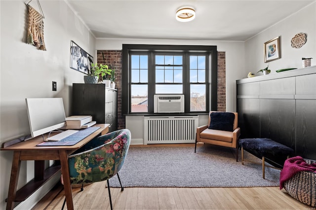 office space featuring light hardwood / wood-style floors, radiator, and cooling unit