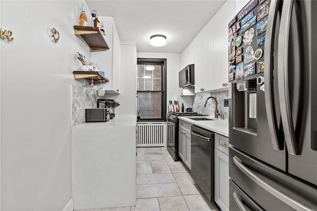 kitchen featuring white cabinetry, sink, stainless steel appliances, backsplash, and light tile patterned floors