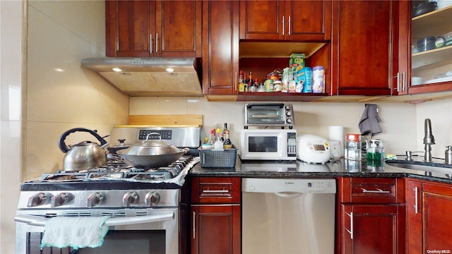 kitchen with sink, dark stone counters, and appliances with stainless steel finishes