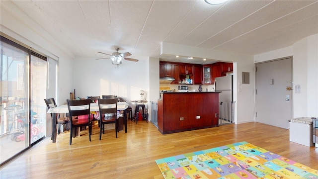 dining space featuring a textured ceiling, light hardwood / wood-style flooring, and ceiling fan