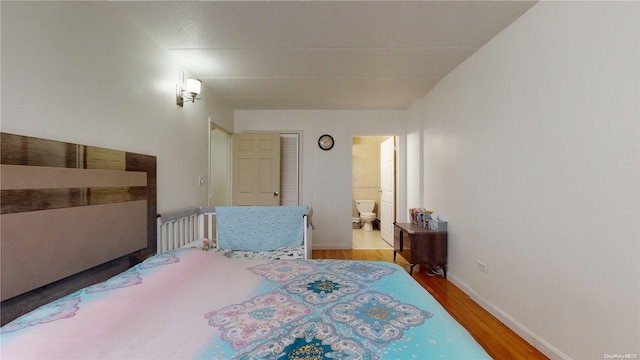 bedroom featuring hardwood / wood-style flooring and connected bathroom