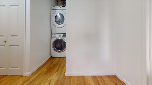 laundry area featuring light hardwood / wood-style flooring and stacked washer / drying machine