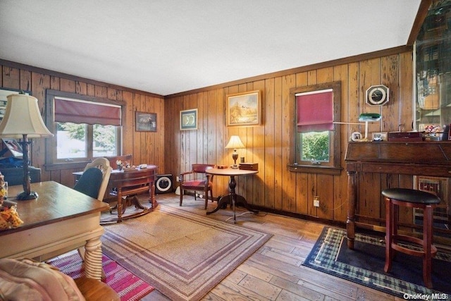 office featuring light wood-type flooring, ornamental molding, and wood walls