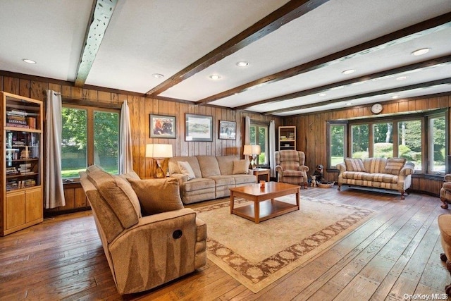 living room featuring hardwood / wood-style flooring, wood walls, and a wealth of natural light