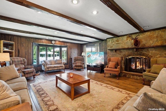 living room with a fireplace, wood walls, light hardwood / wood-style flooring, and beamed ceiling