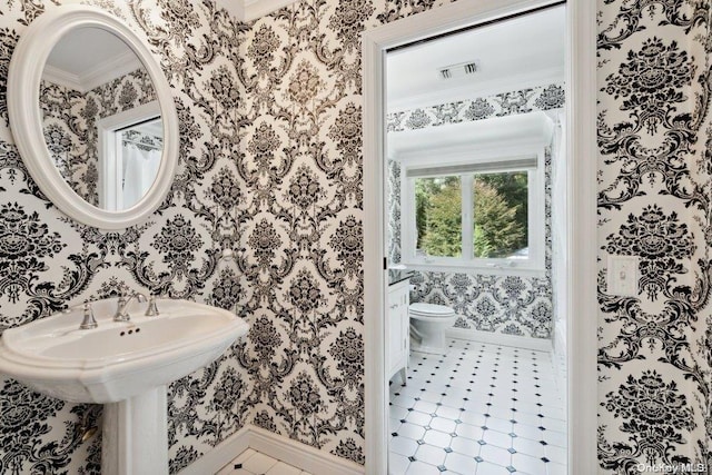 bathroom featuring tile patterned flooring, ornamental molding, and toilet