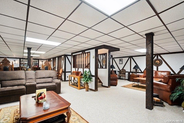 carpeted living room featuring a drop ceiling