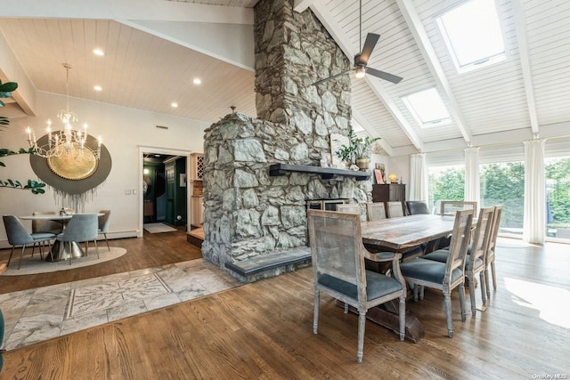 dining room featuring a skylight, a fireplace, high vaulted ceiling, and hardwood / wood-style flooring