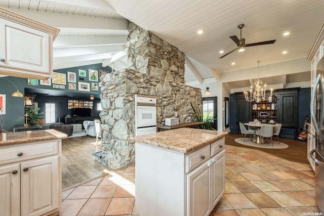 kitchen with oven, a healthy amount of sunlight, light hardwood / wood-style floors, and beam ceiling