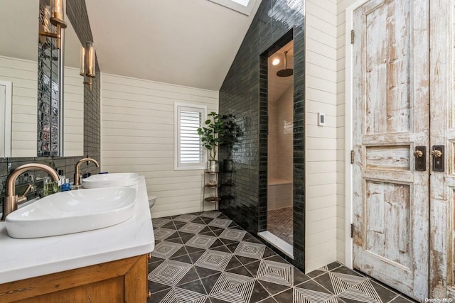 bathroom with tile patterned floors, a tile shower, vaulted ceiling, and wooden walls