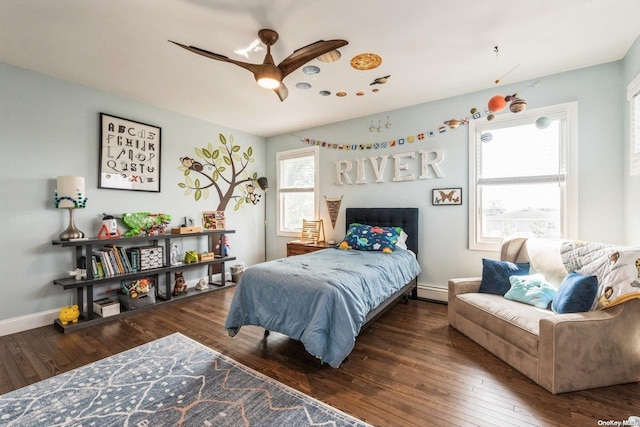 bedroom featuring a baseboard heating unit, ceiling fan, and dark wood-type flooring