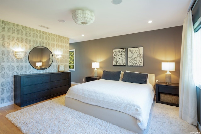 bedroom with light hardwood / wood-style flooring and multiple windows