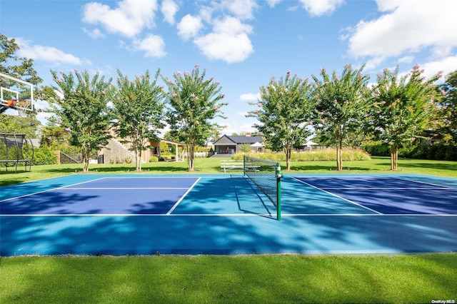 view of sport court with a yard and basketball hoop