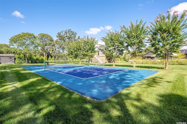 view of sport court with basketball hoop and a yard