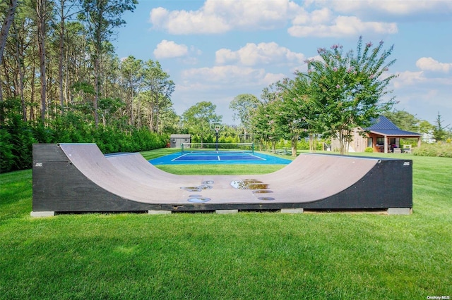 view of pool with a lawn and tennis court