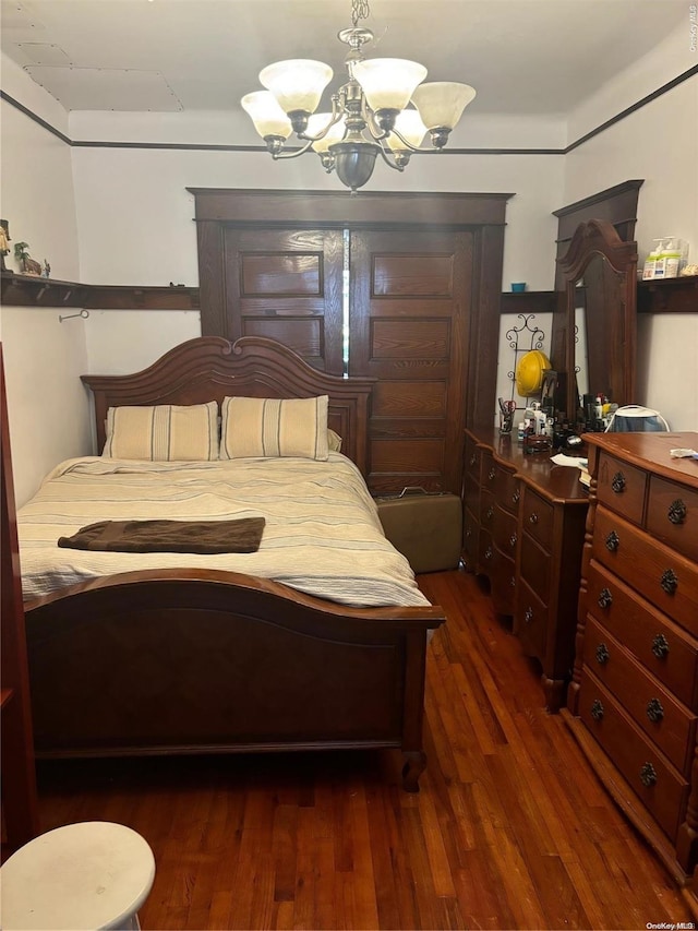 bedroom featuring a notable chandelier and dark hardwood / wood-style flooring