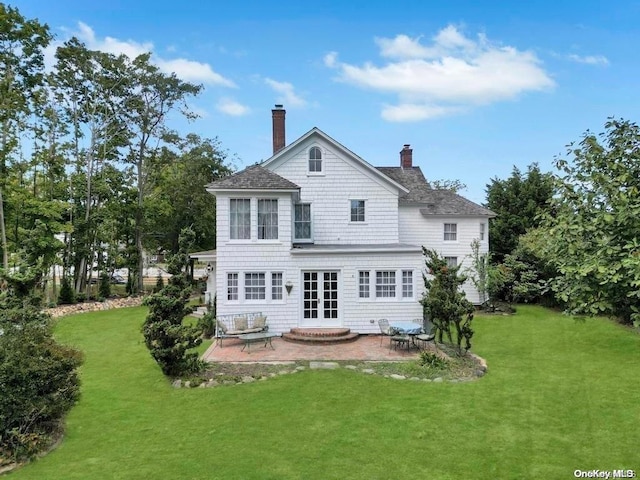 back of house featuring a lawn and a patio area