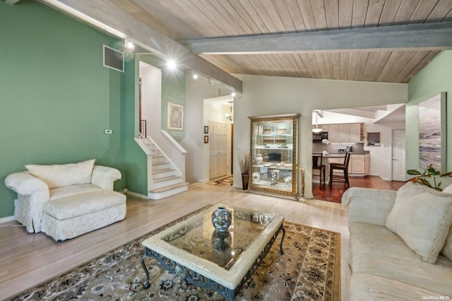 living room with vaulted ceiling with beams, wood ceiling, and light wood-type flooring