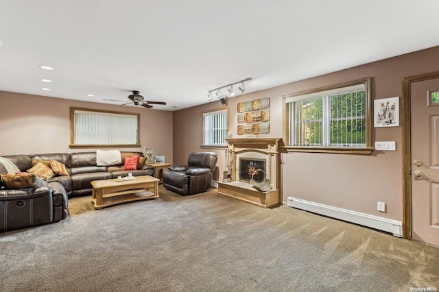 carpeted living room with a baseboard heating unit, track lighting, and ceiling fan