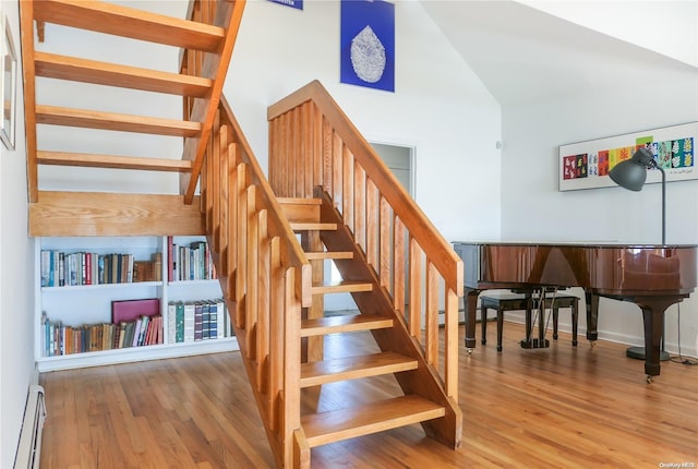 stairway with hardwood / wood-style flooring and baseboard heating