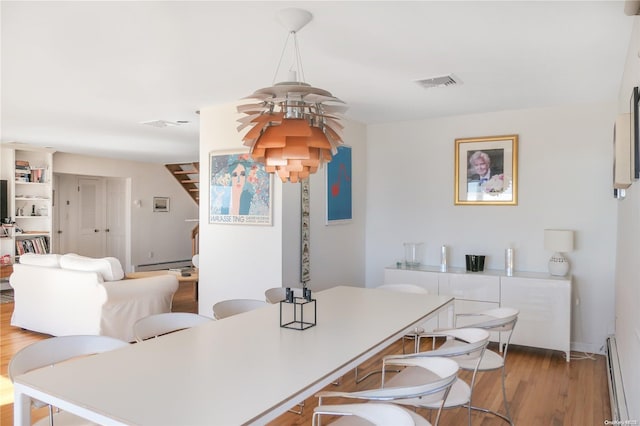 dining room with hardwood / wood-style floors and baseboard heating