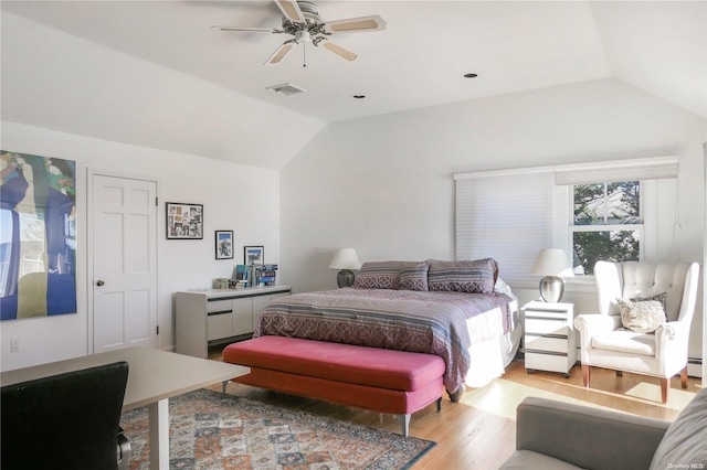 bedroom with light hardwood / wood-style floors, vaulted ceiling, ceiling fan, and a baseboard heating unit