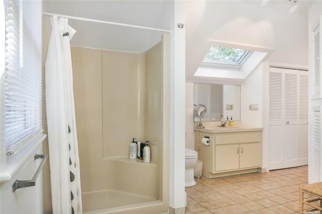 bathroom featuring tile patterned flooring, a shower with curtain, vanity, and a skylight