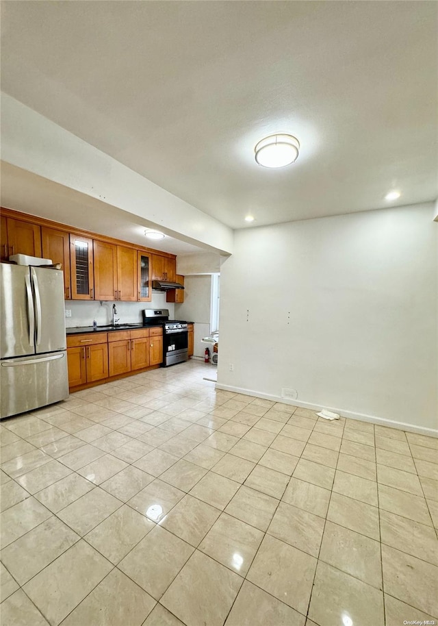 kitchen featuring appliances with stainless steel finishes, sink, and light tile patterned flooring