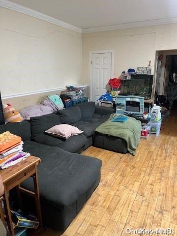 living room featuring hardwood / wood-style flooring and crown molding