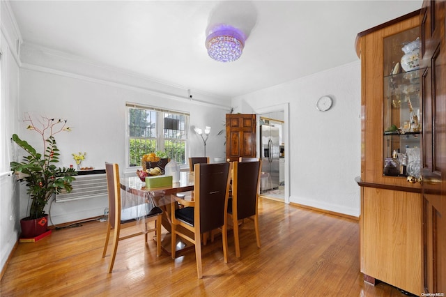 dining area featuring hardwood / wood-style floors and crown molding