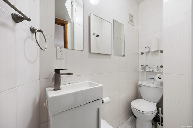 bathroom featuring vanity, tile walls, and toilet