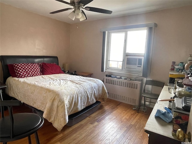 bedroom featuring radiator, ceiling fan, and hardwood / wood-style flooring