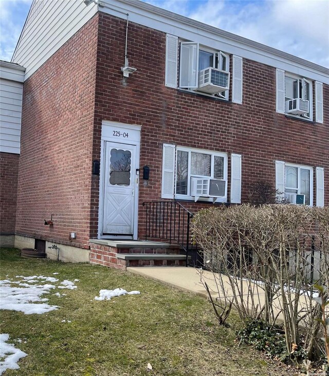 view of front of house featuring cooling unit and a front lawn