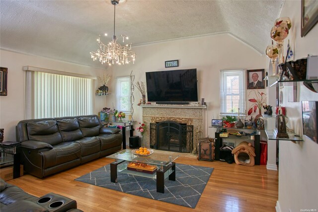 living room with hardwood / wood-style floors, a textured ceiling, and lofted ceiling