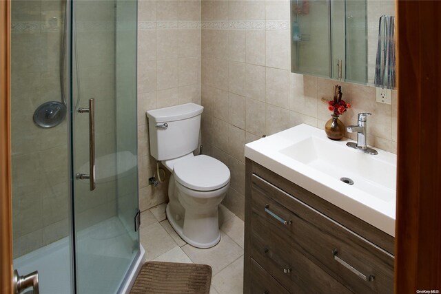 bathroom with vanity, toilet, and tile walls