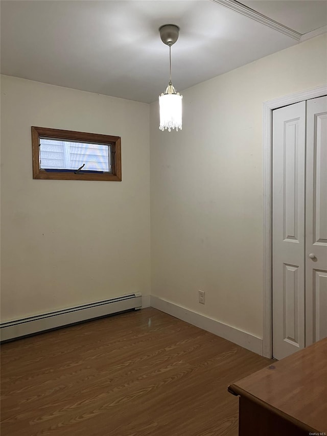 unfurnished room with baseboard heating and dark hardwood / wood-style flooring