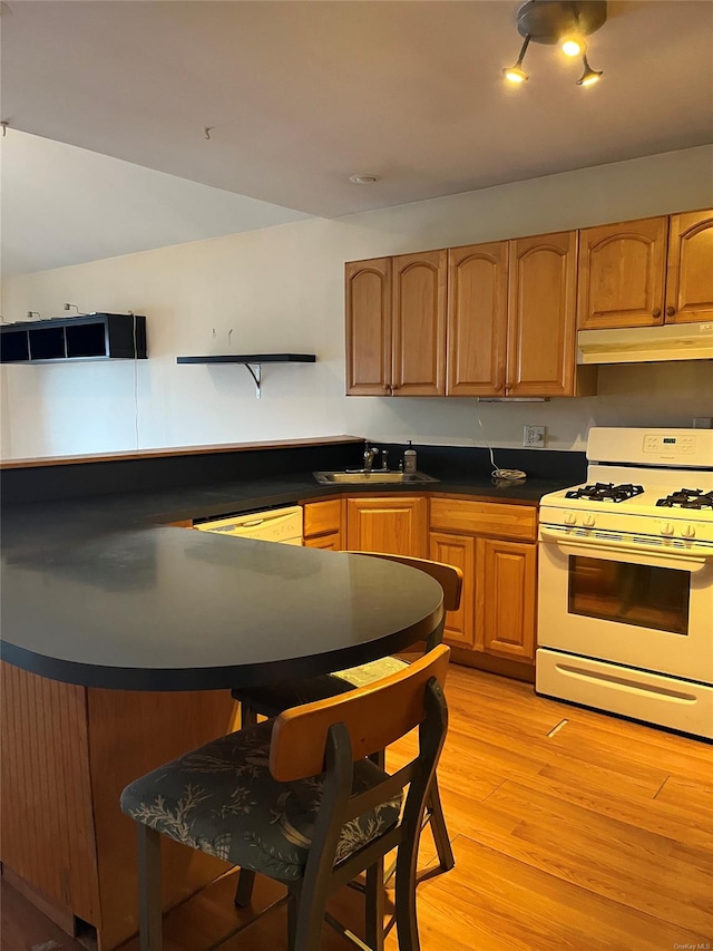 kitchen with sink, white appliances, and light wood-type flooring