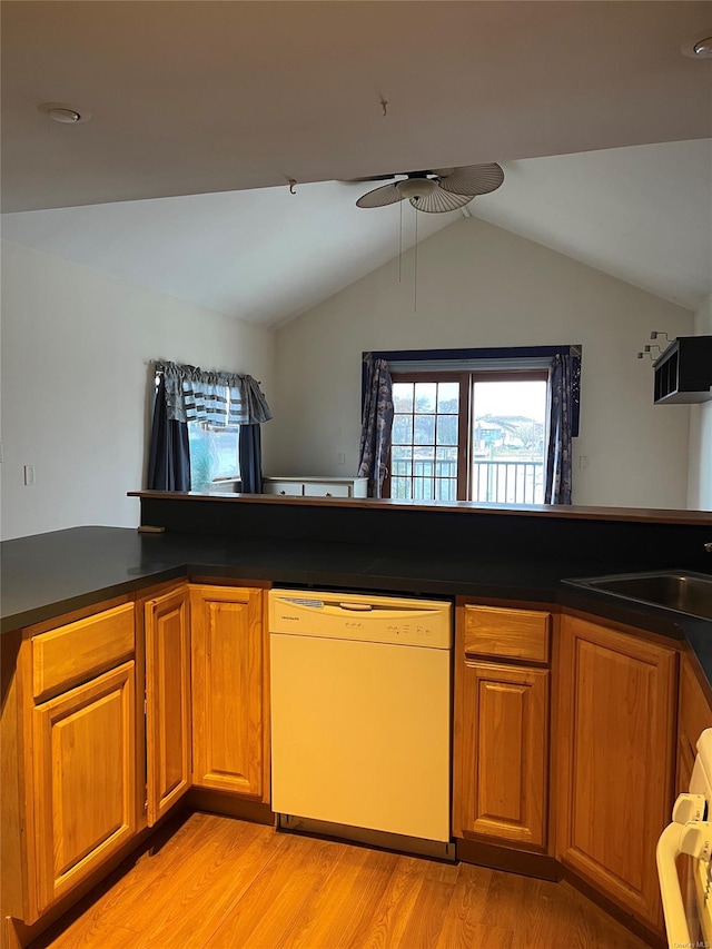 kitchen featuring ceiling fan, dishwasher, kitchen peninsula, light hardwood / wood-style floors, and vaulted ceiling