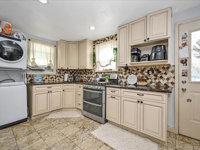 kitchen with cream cabinets, tasteful backsplash, double oven range, and stacked washer and clothes dryer