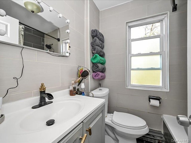 bathroom with curtained shower, vanity, tile walls, and toilet