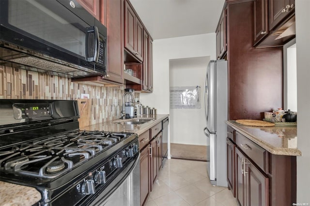 kitchen featuring light tile patterned floors, decorative backsplash, light stone countertops, black appliances, and sink