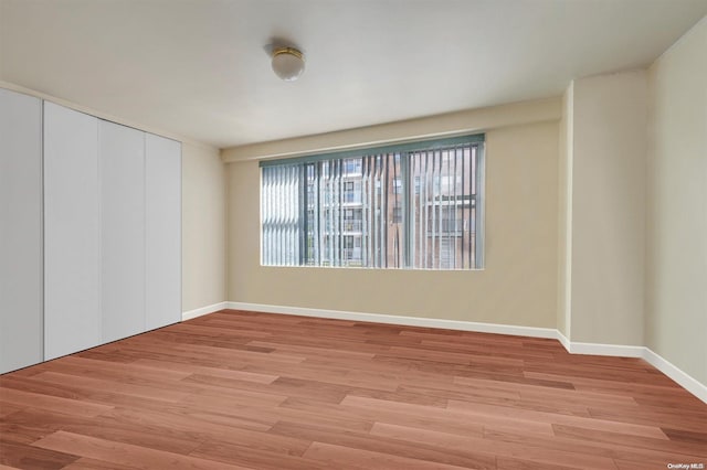 unfurnished bedroom with light wood-type flooring and a closet