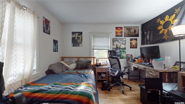 bedroom featuring wood-type flooring and ornamental molding