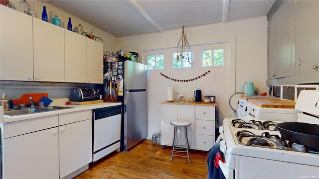 kitchen with white cabinetry, sink, light hardwood / wood-style flooring, white appliances, and decorative light fixtures