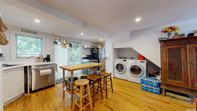 kitchen featuring white cabinetry, sink, stainless steel appliances, light hardwood / wood-style flooring, and independent washer and dryer