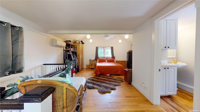 bedroom featuring light hardwood / wood-style floors and an AC wall unit