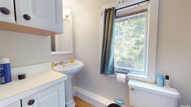 bathroom featuring hardwood / wood-style flooring, a healthy amount of sunlight, and toilet