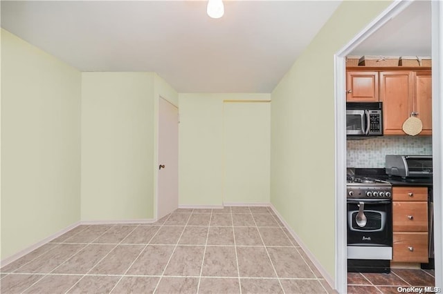 kitchen with backsplash, gas range, and light tile patterned floors